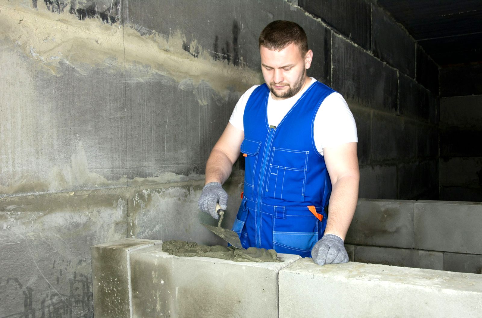 Mason laying concrete block with a trowel